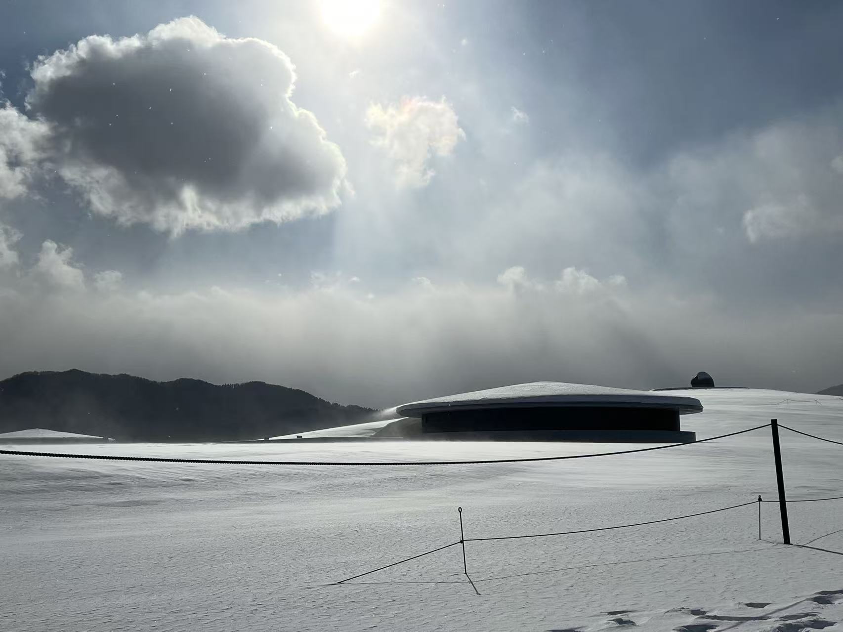 Sun breaking through cloud above a snow landscape in Hokkaido