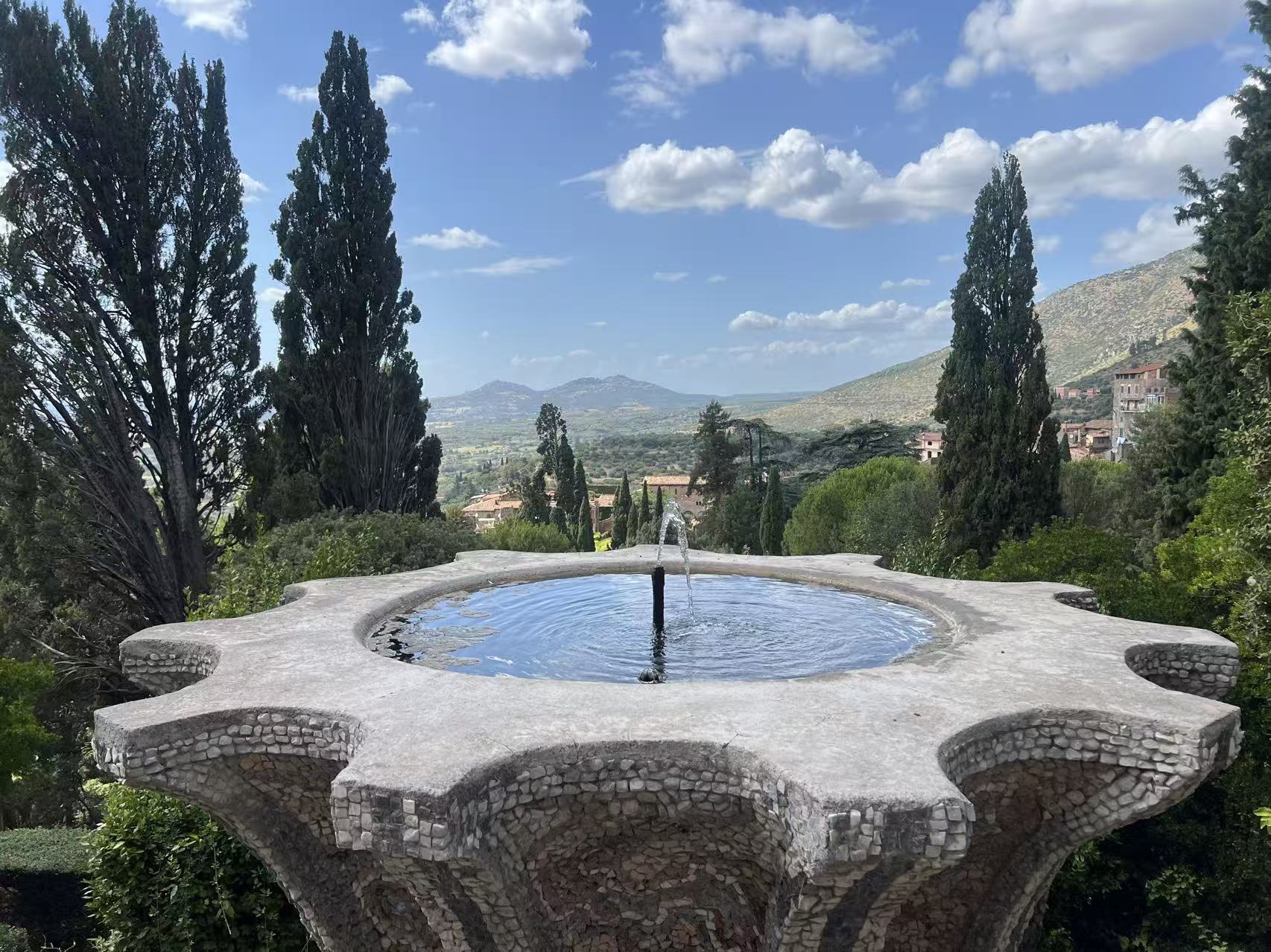A stone fountain overlooking a landscape outside Rome